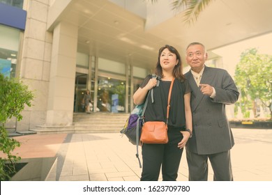 Mature Asian Businessman And Mature Asian Woman Exploring The City Together