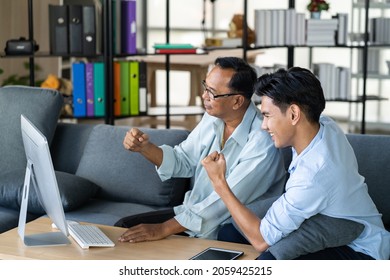 Mature Asian Man With Looking At Computer With Teenage Man . Teaching Internet Online Or Wifi Technology In Older Man Concept.