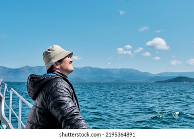 Mature Asian Man As Tourist On Boat Trip. Chivyrkuisky Bay Of Lake Baikal. Zabaikalsky National Park, Buryatia, Russia. Travel Concept