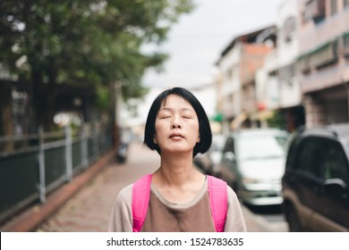 Mature Asian Traveling Woman Close Eyes And Feel Free At Street