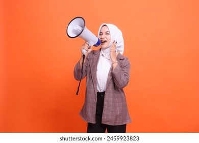 Mature asian woman in hijab candid top shouting holding megaphone palm beside mouth isolated on orange background, Speech, announcing, advertising, broadcast concept - Powered by Shutterstock