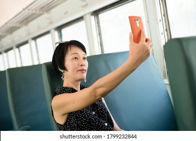 Mature Asian Woman Take A Selfie At A Carriage Of Train