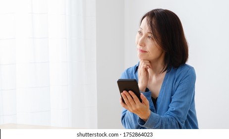 Mature Asian Woman Using Smart Phone