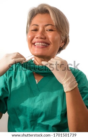 mature attractive and happy medicine doctor woman or experienced hospital nurse in medical scrubs in face mask with hands in latex gloves confident and cheerful