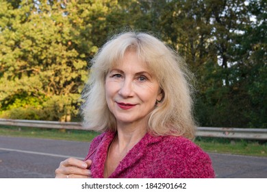 Mature Beautiful Woman With Happy Face At Nature. Blond Hair Lady 50-60 Years Old. Attractive Aged Female Portrait. Summer Or Early Autumn Photo With Adult Friendly Person. 