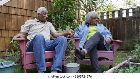 Mature black couple resting together after gardening