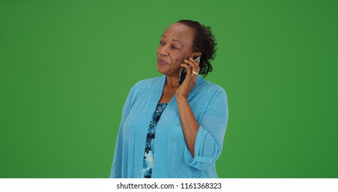 Mature black female talking on smartphone on green screen