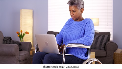 Mature Black Woman Sitting In Wheelchair With Laptop