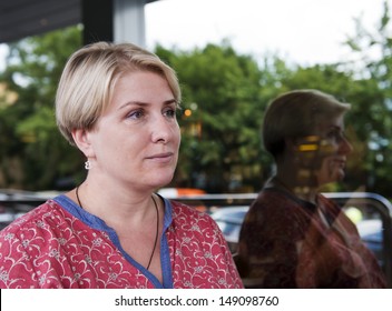 Mature Blond Woman And Her Reflection In The Window. Real People Series