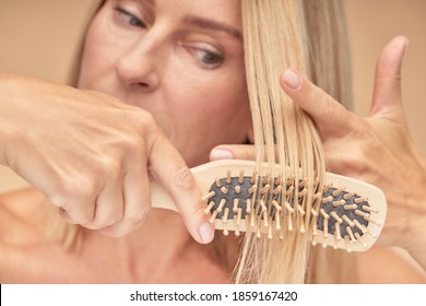 Mature Blonde Woman Combing Her Hair, Selective Focus