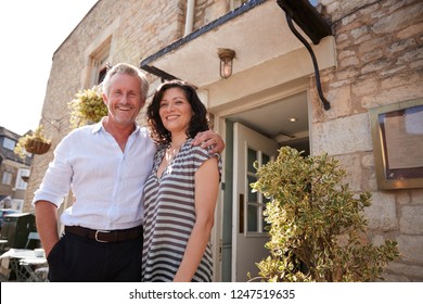 Mature Business Couple Standing Outside Their Restaurant Pub