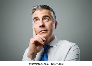 Mature Business Man Looking Up And Thinking About Something