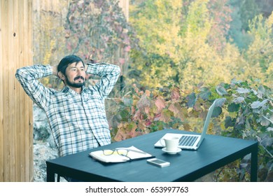 Mature Business Person In Casual Shirt Smiling And Relaxing After Finishing The Project At Outdoor Terrace Of Suburban Cottage