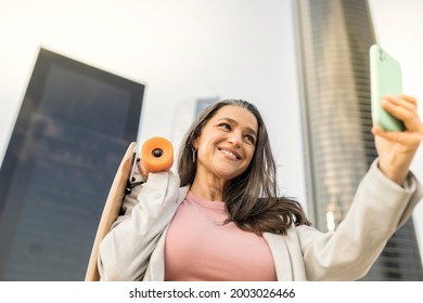 Mature Business Woman With Skateboard And Smartphone Making Selfie In The City