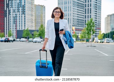 Mature Business Woman Walking With Suitcase, Modern City Background