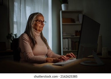 Mature Business Woman With Working On Laptop In Office At Night.