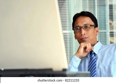 Mature Businessman Looking At Information On A Laptop Computer