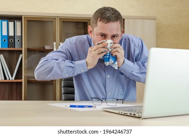 Mature Businessman At Office Desk Blowing His Nose. A Cold Office Worker Blows His Nose Into A Handkerchief. Cold And Sickness In The Workplace. Allergy