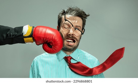 Mature businessman in red tie getting boxing punch in jaw from business competitors. Concept personal challenge, financial loses, business fall, deadlines, economic crisis, bad investment. Sport, ad