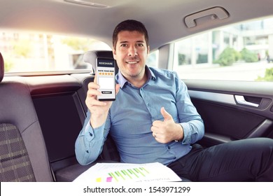 Mature Businessman Sitting On Backseat Of Car Rating Cab Services On App While Commuting To Work – Business On The Go With Mature Man Traveling By Taxi – Male On Mobile Phone Giving Excelent Review