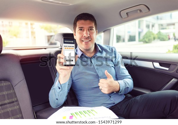 Mature businessman sitting on backseat of car\
rating cab services on app while commuting to work – business on\
the go with mature man traveling by taxi – male on mobile phone\
giving excelent review