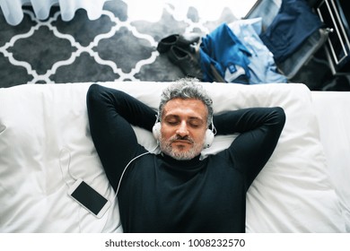 Mature businessman with smartphone in a hotel room. - Powered by Shutterstock