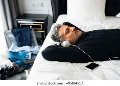 Mature businessman with smartphone in a hotel room. - Powered by Shutterstock