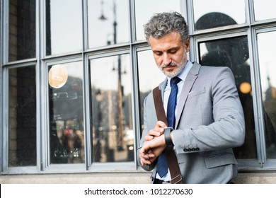 Mature businessman standing in a city. - Powered by Shutterstock