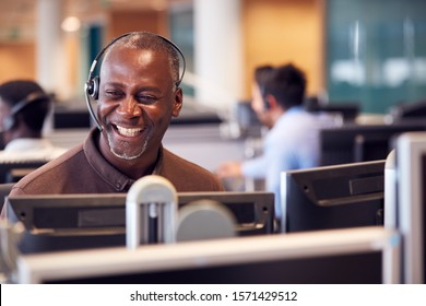 Mature Businessman Wearing Telephone Headset Talking To Caller In Customer Services Department - Powered by Shutterstock