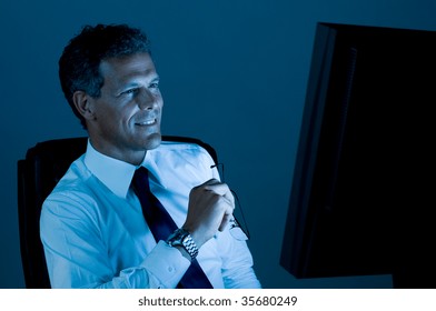 Mature Businessman Working Late At Night In His Office