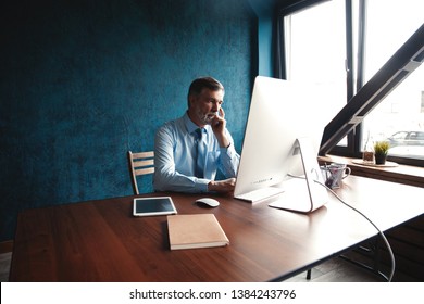 Mature Businessman Working On Computer In Modern Office