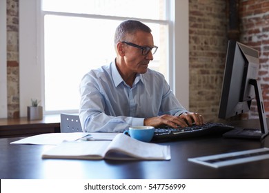 Mature Businessman Working On Computer In Office