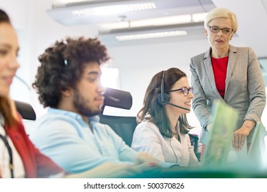 Mature businesswoman with operators working in office - Powered by Shutterstock