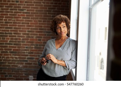 Mature Businesswoman Standing By Office Window