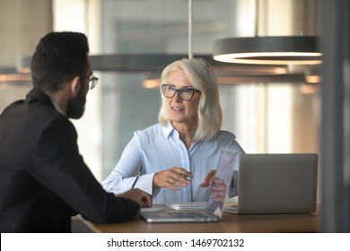 Mature businesswoman talking with business partner in office, senior manager consulting client about loan, insurance, hr holding interview with job applicant, aged mentor training trainee