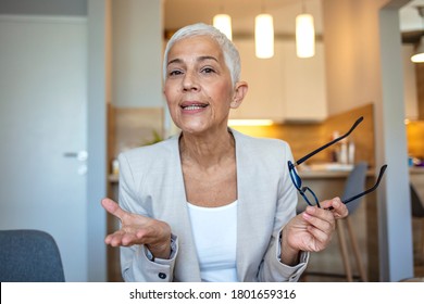 Mature Businesswoman Wearing Glasses Looking At Camera And Talking, Discussing Strategy With Partners Online, Senior Business Coach Mentor Recording Webinar, Hr Manager Holding Distance Job Interview