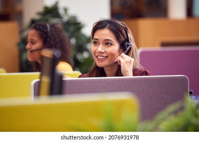 Mature Businesswoman Wearing Phone Headset Talking To Caller In Busy Customer Services Centre - Powered by Shutterstock