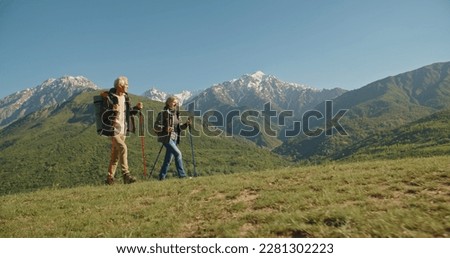 Mature caucasian couple on vacation, having a hike in spring mountains, spending time together after retirement together travelling - tourism, pension concept