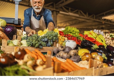 A mature Caucasian vegetable owner arranging vegetables at his stall getting ready for the day. ストックフォト © 