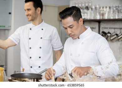 Mature Chef In Kitchen Cooking Dish For Dinner, 30-40 Year Old.