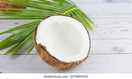 Mature coconuts with brown shells are cut in half and white flesh pressed to make coconut milk for sweet and savory dishes and extracted for use as cosmetics.