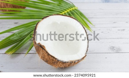 Mature coconuts with brown shells are cut in half and white flesh pressed to make coconut milk for sweet and savory dishes and extracted for use as cosmetics.
