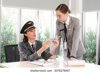 Mature commercial female pilot is training young flight crew. Professional middle aged woman airplane captain flight instructor has meeting discussion with aircrew student. Aviation business concept - Powered by Shutterstock