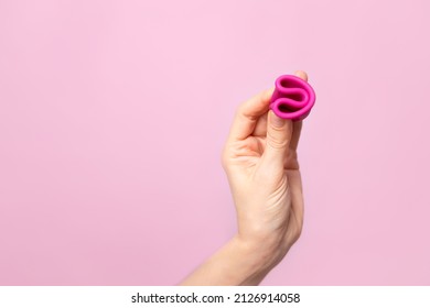 Mature Content A Young Woman Folding A Pink Menstrual Cup In Her Hand. Pink Colored Background. Space For Text. Eco-friendly Silicone. Women's Health Cycle High Quality Photo