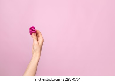 Mature Content A Young Woman Folding A Pink Menstrual Cup In Her Hand. Pink Colored Background. Space For Text. Eco-friendly Silicone. Women's Health Cycle High Quality Photo