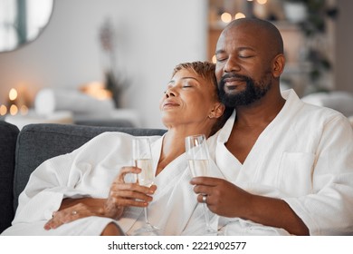 Mature Couple, Bonding And Champagne On Spa Date, Romantic Retreat Or Resort Holiday For Marriage Anniversary Celebration. Black Woman, Man And Alcohol Glass On Relax Salon Or Hotel Living Room Sofa