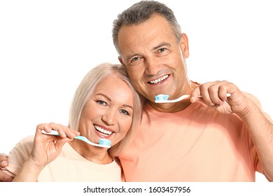 Mature Couple Brushing Teeth On White Background