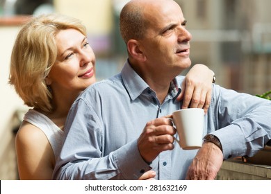 Mature couple discussing and drinking tea at balcony - Powered by Shutterstock