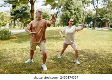 Mature couple enjoying practicing tai chi outdoors - Powered by Shutterstock