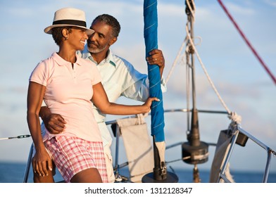 Mature Couple Enjoying View Of Water From Boat Deck.